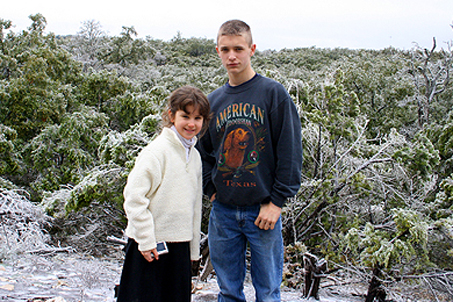 Sam and Mary in front of an icy canopy of tree tops